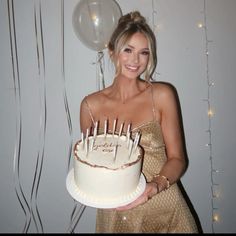 a woman holding a cake with candles on it