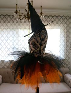 a black and orange witch costume sitting on top of a couch