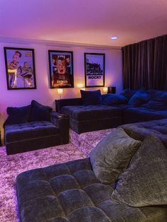 a living room with couches and pictures on the wall above them in purple lighting