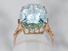 This aquamarine cocktail ring makes quite the statement! This exquisite gemstone is one of the finest quality aquamarine currently in our collection, filled with glitter and shine, this high-quality stone has been expertly faceted to bring out the highlights of teal and cerulean. This is the ultimate collector's piece for any aquamarine lover!Metal: 14K Yellow GoldGem: Aquamarine 16.30 CaratsGem Measurements: 19.2 x 12.6 mm, Cushion CutRing Size: 7Marks: “14” Stamped on the inside band Formal Light Blue Aquamarine Diamond Ring, Luxury Aquamarine Diamond Ring With Prong Setting, Luxury Aquamarine Rings With Prong Setting, Formal Aquamarine Diamond Ring With Prong Setting, Luxury Light Blue Topaz Ring With Center Stone, Elegant Light Blue Aquamarine Diamond Ring, Elegant Light Blue Diamond Ring, Luxury Aquamarine Emerald Cut Rings, Luxury Aquamarine Emerald-cut Rings