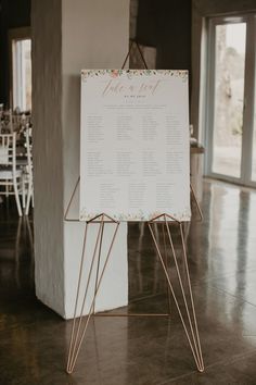 a sign that is sitting on the floor in front of a table with chairs and tables