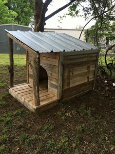 a wooden dog house with a metal roof