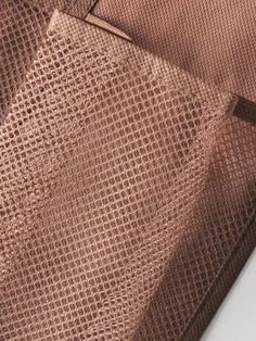 a close up view of a tie on a white tablecloth with brown and tan patterns