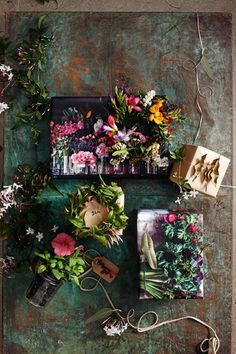 flowers and other items are arranged on a green surface with twine cords, scissors and string