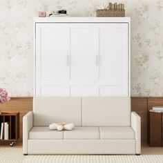 a living room with a couch, bookcase and two vases on the floor