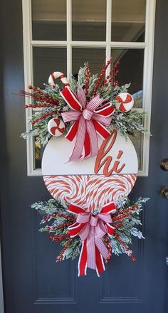 a door hanger decorated with candy canes and greenery for the holiday season