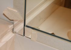 the reflection of a sink and mirror in a bathtub with white tile on the floor