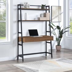 a computer desk sitting on top of a wooden shelf next to a potted plant