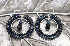 Handmade black boho statement earrings in the most gorgeous mix of iridescent and black beads. These artisan beaded hoop earrings were made with several sizes and shapes of seed beads. Each tiny bead is selected and hand sewn into place, one at a time with a needle and thread. No plastics, no glue, no looms - completely hand stitched with strong nylon thread.✔️Ear wires are sterling silver.✔️handmade in the USA✔️ships boxed and ready to gift in 3-5 business days with care instructions✔️lightweig Black Bohemian Earrings With Faceted Beads, Handmade Black Beaded Small Hoop Earrings, Black Beaded Round Hoop Earrings, Handmade Black Hoop Earrings For Festival, Black Boho, Beaded Hoop Earrings, Beaded Hoops, Needle And Thread, Black Beads