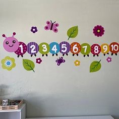 a child's room with a wall decal that has numbers and bugs on it