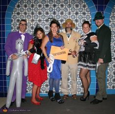 a group of people standing next to each other in front of a blue tile wall