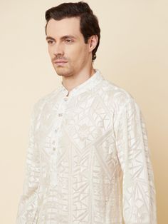 This Lucknowi kurta will instantly give an elegant look. Made from polyester cotton fabric, this 2 piece kurta set features a white lucknowi kurta, front buttons fastening, designer cuff buttons, and a mandarin collar. This lucknowi kurta has beautiful chikankari embroidery work all over. It is paired with white churidar pants. An ideal outfit for traditional & special events.

Size Chart For Men





	
	
					Men's Size Chart
		

		
		
						
				Size Chart For Men
				Custom Size Measurement G White Naqshi Kurta For Festive Occasions, White Straight Kurta With Naqshi Details, Festive White Kurta With Naqshi Detailing, White Straight Kurta With Naqshi, White Kurta With Naqshi For Eid, White Naqshi Straight Kurta, White Kurta For Eid, White Chikankari Embroidery Bandhgala For Eid, White Bandhgala With Chikankari Embroidery For Eid