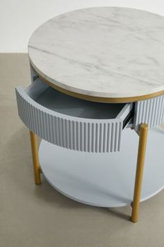 a marble top coffee table with two drawers on one side and an open drawer in the other