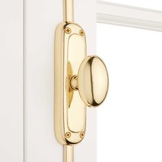 a close up of a door handle on the side of a white door with gold hardware