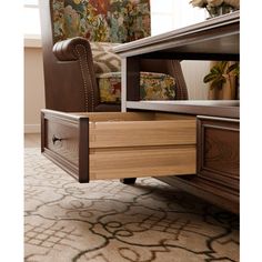 a brown chair sitting on top of a wooden table next to a dresser with drawers