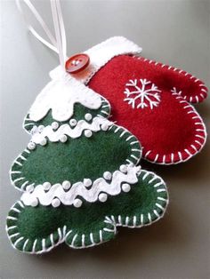 two christmas ornaments hanging on a table with buttons and string attached to the ornament