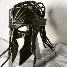 a helmet with braids on it sitting on top of a table