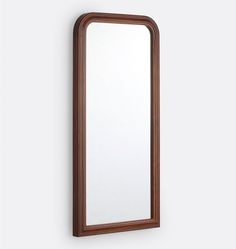 a mirror mounted to the side of a wall next to a wooden frame on a white wall