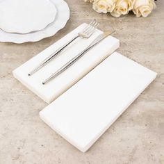 there are two forks and one knife on the placemat next to some white roses