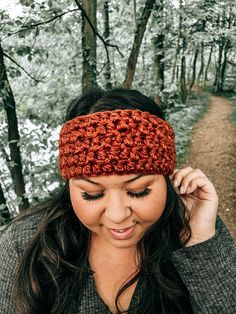 a woman wearing a crochet headband in the woods