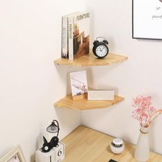 three shelves with books and other items on them in a corner next to a clock