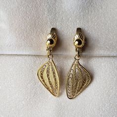 "Vintage TRIFARI TM Gold Tone Filigree Leaf Clip-On Earrings Modernist Design Minimalist Earrings These vintage clip-on earrings in gold-tone filigree are from Trifari. The comfort clip design and their weight, 4.52 grams, contribute to their comfort. They measure about 1 1/2\" long by 1/2\" wide.  As with all authentic vintage Trifari, these earrings are signed. The \"TRIFARI TM\" hallmark was used on the last of the signed pieces from the late 1980s to 1999. 081920" Gold Clip-on Earrings, Elegant Adjustable Clip-on Earrings, Clip Design, Modernist Design, Vintage Trifari, Design Minimalist, Vintage Clip, Dec 30, Minimalist Earrings