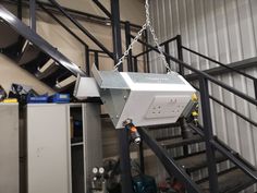 a machine that is sitting on some kind of metal rail in a warehouse or building