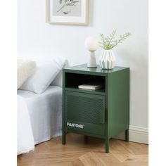 a small green cabinet next to a bed