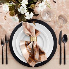 a place setting with napkins, silverware and flowers