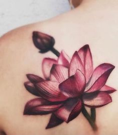 a woman's back with a pink flower tattoo on her upper arm and shoulder