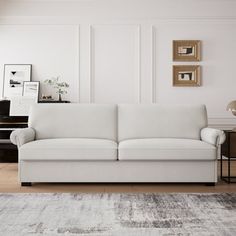 a living room with a white couch and a piano in the backgroung