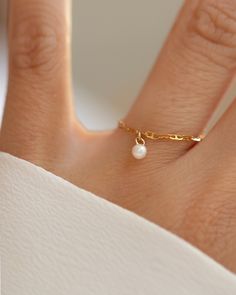 This 14k Solid Gold Chain Ring features a delicate link design and a dainty dangling pearl, creating a modern yet timeless accessory. Worn solo or paired with other rings, it adds a touch of elegance to any look. •14k gold•Fresh water pearl•Pearl measures about 4mm Gold Chain Ring, Anchor Chain, Link Design, Solid Gold Chains, Diamond Free, Fresh Water Pearl, Timeless Accessories, Stacking Ring, Chain Ring