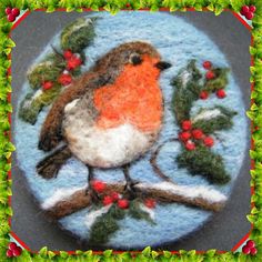 a felt ornament depicting a bird on a branch with berries and mists