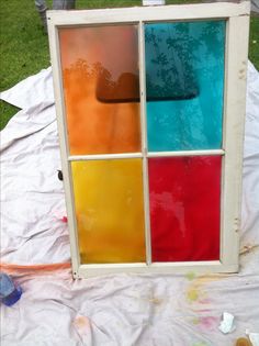 an old window is being painted with different colors and shapes to make it look like they are