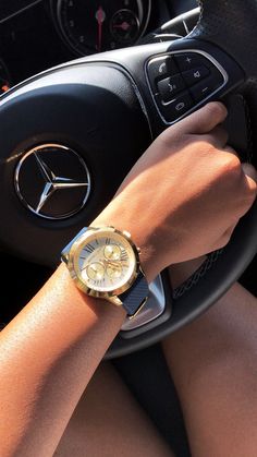 a woman is holding the steering wheel of her car