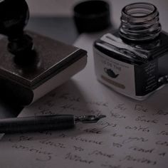 a pen and ink bottle sitting on top of a piece of paper