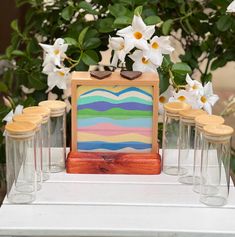 a table topped with vases filled with white flowers and small wooden boxes on top of it