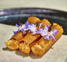 some food that is sitting on top of a cloth with purple flowers in the middle