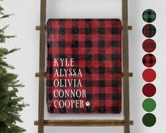 a red and black checkered blanket sitting on top of a wooden ladder next to a christmas tree