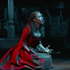 a woman in a red dress is sitting down