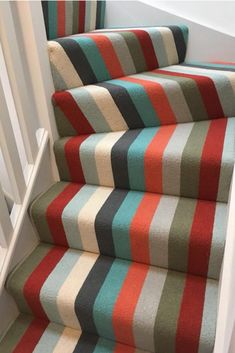 a striped carpeted stair runner on the stairs