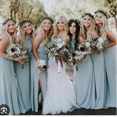 a group of women standing next to each other wearing dresses and holding bouquets in their hands