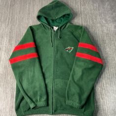 a green hoodie with red stripes on the side and a logo on the front