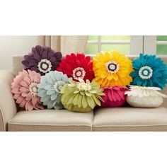 colorful flower pillows sitting on top of a couch