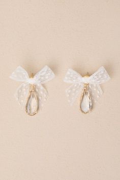 You'll take any chance you get to wear spectacular accessories like the Petit Moments Successful Elegance White Tulle Bow Rhinestone Earrings! These too-cute earrings offer a darling aesthetic thanks to chic bows of white lace ribbon (with a dainty polka dot design throughout), that sit above dangling, clear teardrop-shaped rhinestones that shimmer and shine within gold-toned settings. Post backs. 1. 25'' Long And 2'' Wide. 45% Lace, 35% Glass, 10% Brass, 10% Stainless Steel. Imported. Lulus | S White Lace Ribbon, Ethereal Garden, Tulle Bow, Tulle Bows, Shimmer And Shine, Shimmer N Shine, White Tulle, Lace Bows, Polka Dot Design