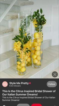 two vases filled with lemons and flowers on top of a white countertop