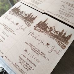 three wooden wedding programs are sitting on a table