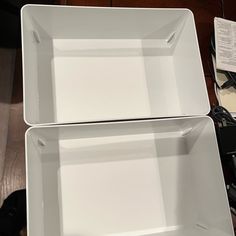 two white square plates sitting on top of a wooden table