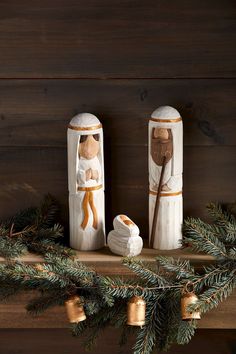 two salt and pepper shakers sitting on top of a mantle with christmas decorations around them