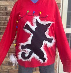 a red sweater with a black cat on it